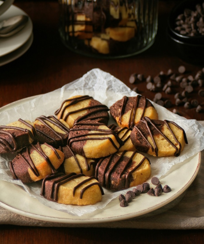 A plate of vanilla chocolate cookies drizzled with chocolate. 